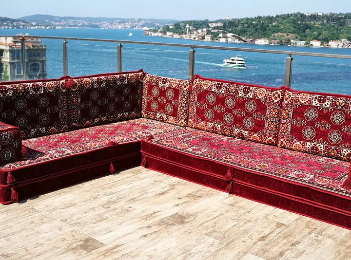 Maroon corner seating shown bare, without ottoman or pillows, so both runs of thick seat cushions are clearly visible