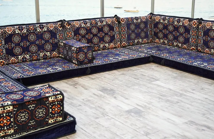 Long navy blue run of floor seating on three walls, the octagonal guls repeating across every backrest