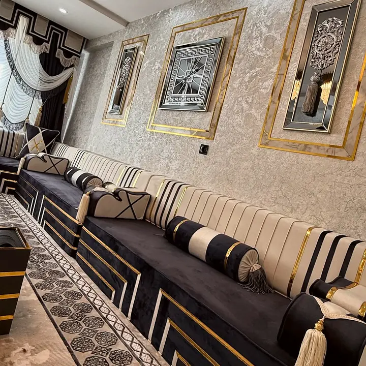 Black velvet seat with stepped gold lines, ivory backrests striped in black and a tasseled striped bolster below framed wall panels