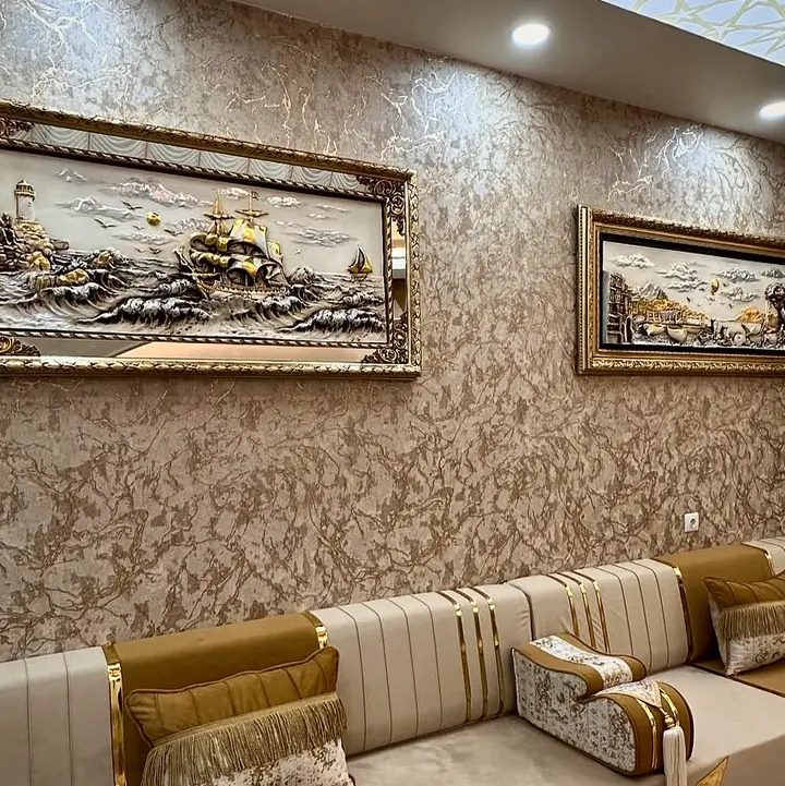 Two framed gilded relief pictures above cream channel-stitched backrests with caramel panels, gold bands and a fringed pillow