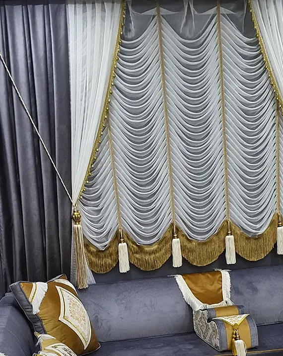 Plush charcoal corner majlis with mustard-gold bands, damask armrest covers with white fringe and a swag valance with gold fringe