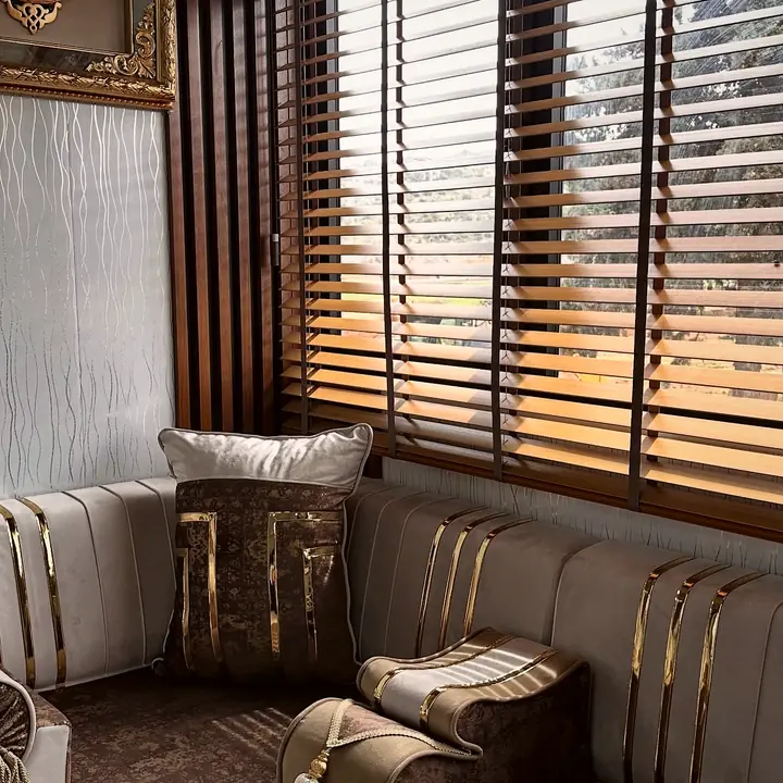 Rounded corner seat in chocolate velvet with gold-banded greige backrests, a tasseled bolster and a sculpted armrest
