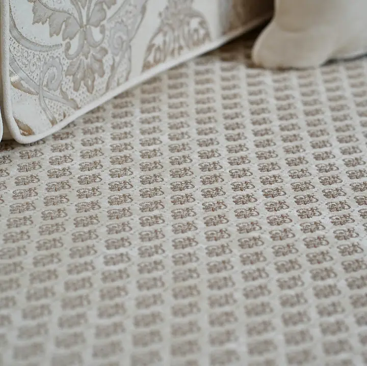 Detail of the cream quilted seat fabric with its small lattice stitching beside a damask back cushion