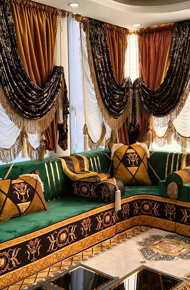 Corner of an emerald majlis where two runs meet, showing the gold baroque print on the base and geometric pillows