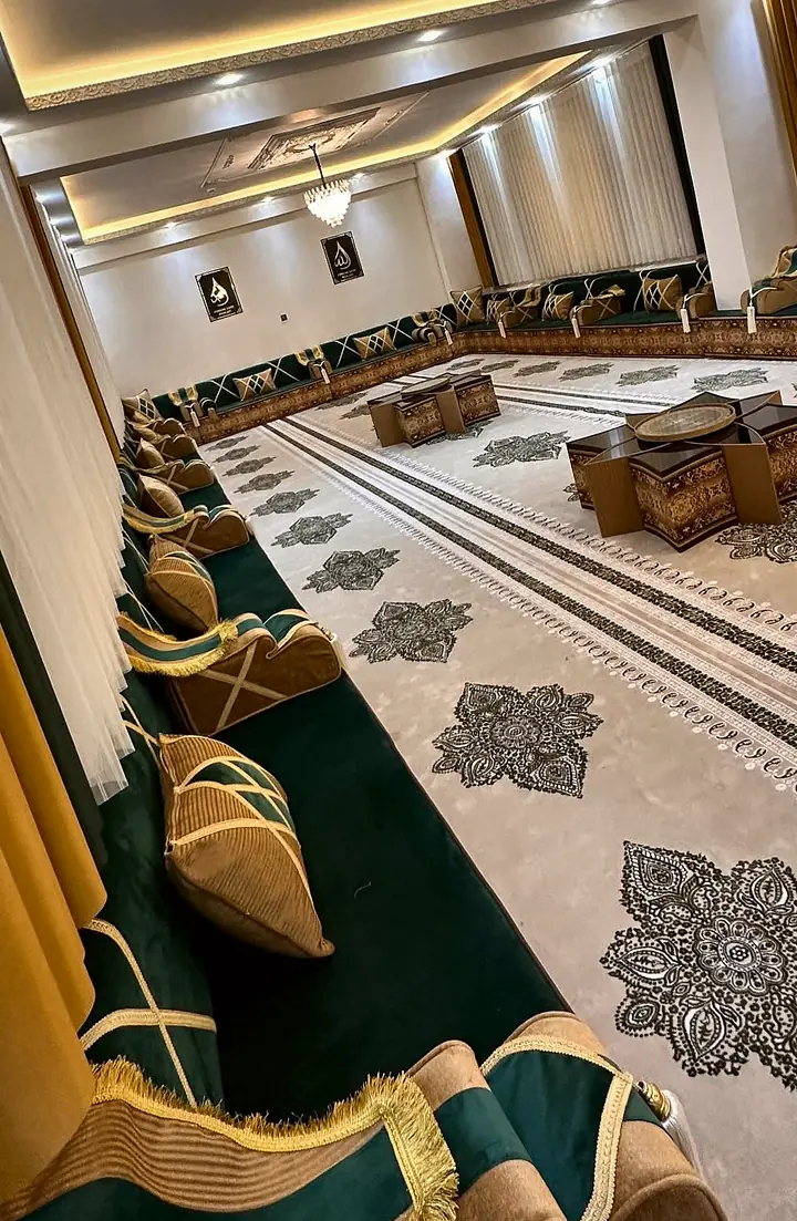 Fringed caramel armrest at the end of a green run, with the far-end seating and tables of the hall in the distance