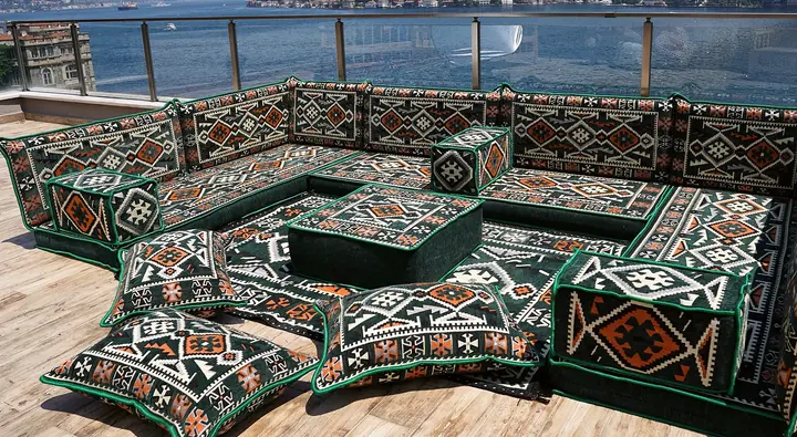 Large green kilim U-shaped set with an ottoman and floor cushions arranged on a matching rug