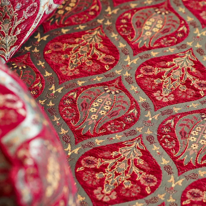 Close view of the red and gold weave, with stylized tulips set inside a lattice of pointed ogee frames