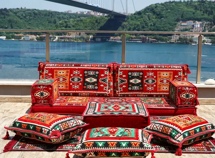 Red kilim floor sofa for one wall, with an ottoman and three floor pillows lined up in front of the seat