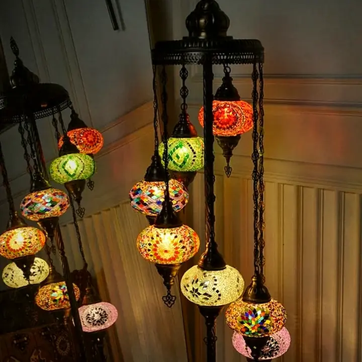 Floor lamp holding a cluster of colorful glass globes on one stand, glowing in a dim room with paneled walls