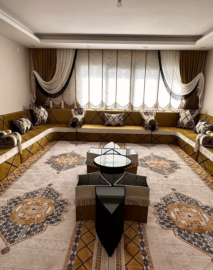 Mustard velvet U-shaped majlis with black diagonal lines and white edging, a cream medallion carpet and a star-shaped center table