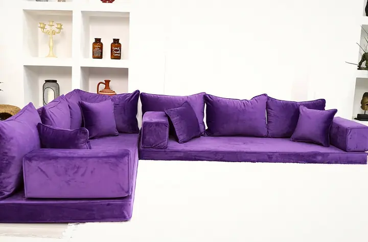 Purple velvet floor seats turn a corner beneath plain matching backrests and armrest blocks, leaving an open front