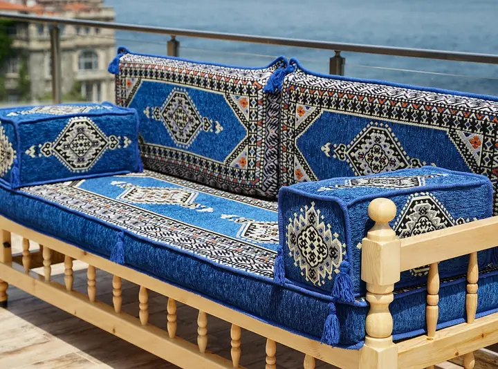 Royal blue and navy medallion back cushions with tasseled box armrests on one wooden bench with a turned spindle front rail