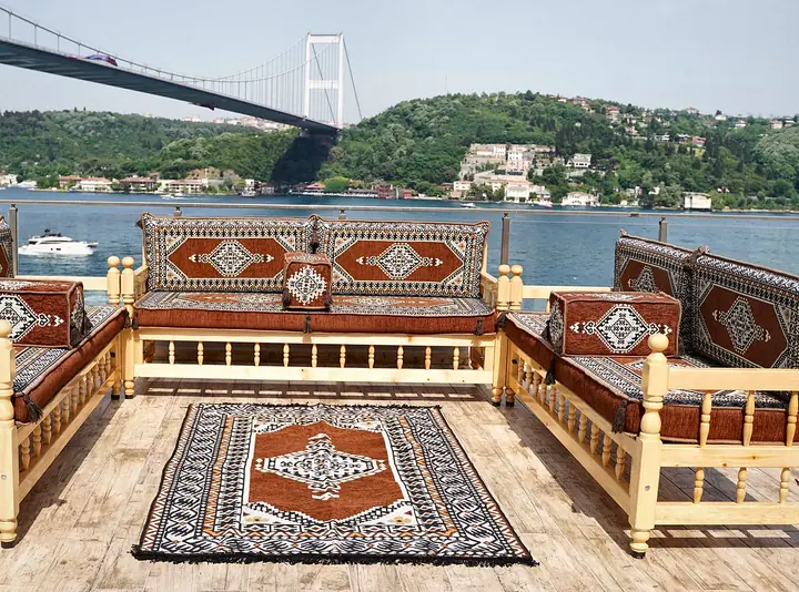 Rust brown medallion seating on a U of raised wooden benches, with a patterned rug laid between the three runs