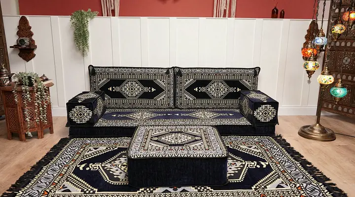 Navy medallion floor seating along one wall, an ottoman on a fringed matching rug and mosaic lamps against a terracotta wall