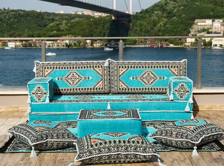 Turquoise Saray seat for one wall with three floor pillows grouped around a matching ottoman in front of it