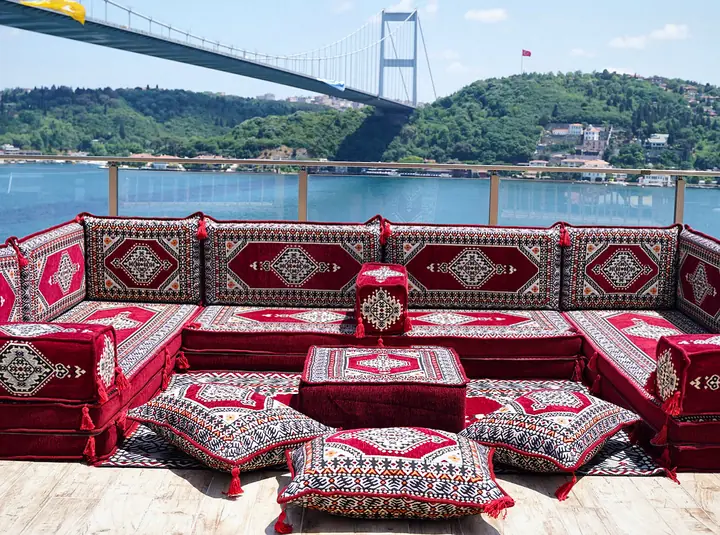 Maroon medallion seating on three sides with an ivory-framed pattern, a center ottoman and floor cushions
