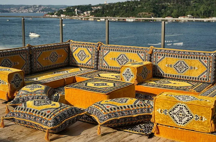 Mustard yellow Saray U set with black-framed medallions, an ottoman and matching floor pillows in front