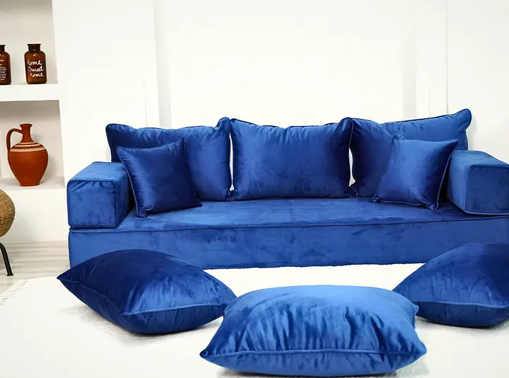 Royal blue velvet single floor seating with square backrests, two small throw pillows and three blue floor pillows