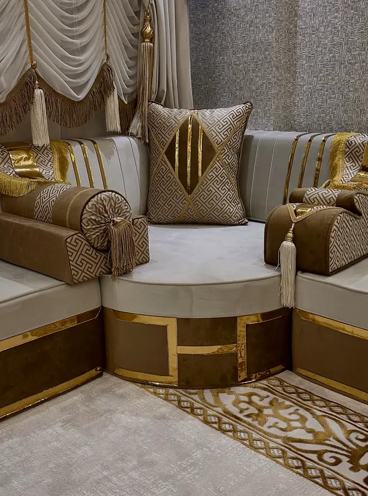 Curved corner seat in ivory velvet on a gold-framed mocha base, with Greek-key armrest covers, gold fringe and ivory tassels