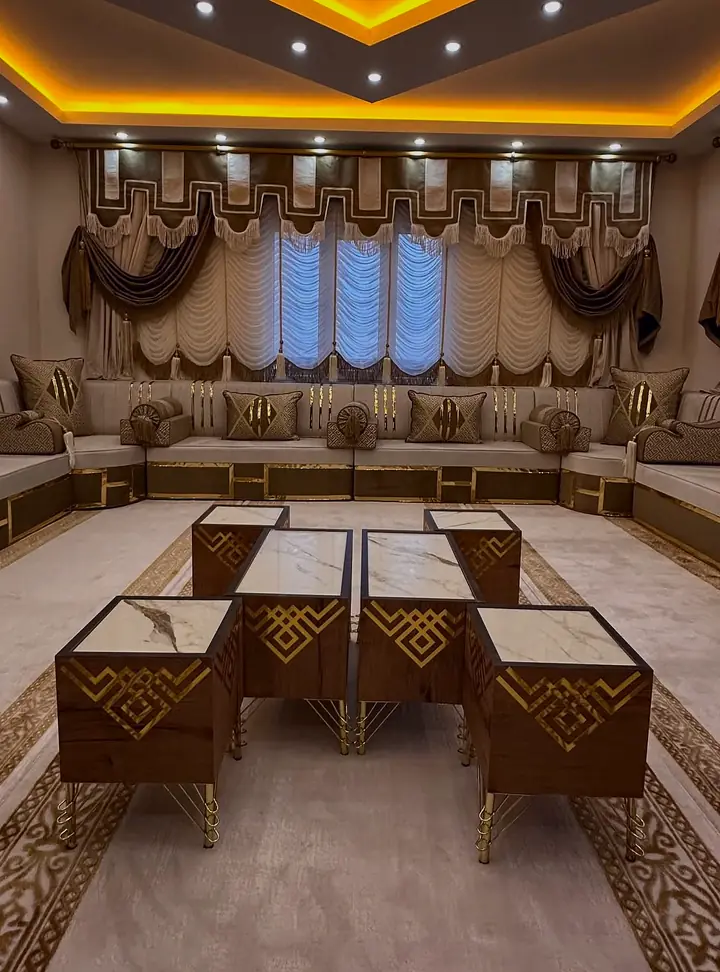 Cream and gold majlis around a room with stepped mocha valances, festoon blinds and wood-grain tables with marble-look tops