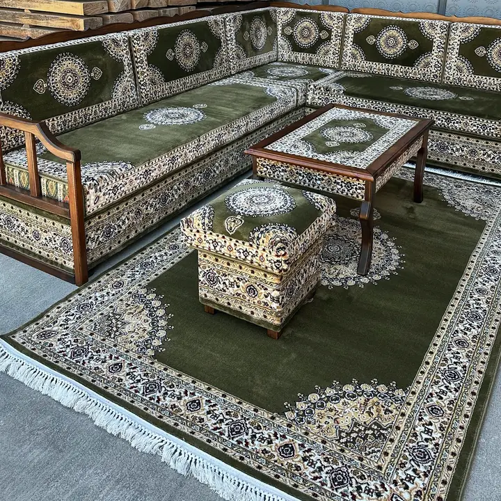 Khaki carpet-weave cushions on dark wooden bench frames set in a corner, with a matching coffee table, ottoman and medallion rug